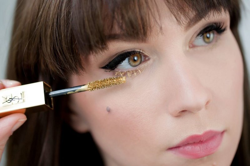Makeup med piler og gyllen mascara på de nedre øyevippene