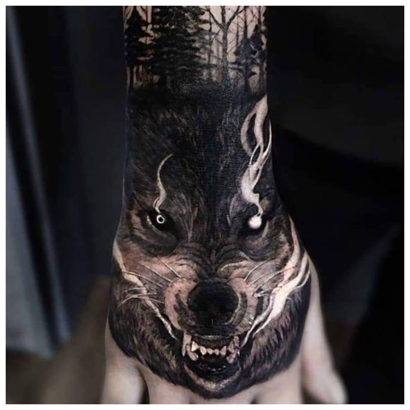 Ulves munn tatovering på en manns hånd