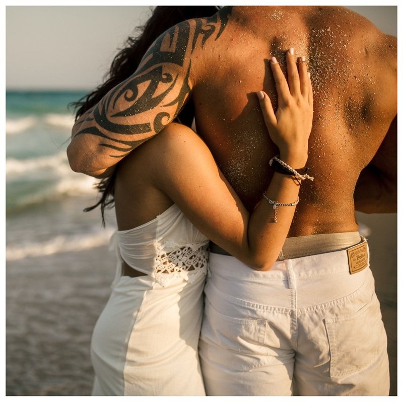 Cuplu cu tatuaje pe plajă.