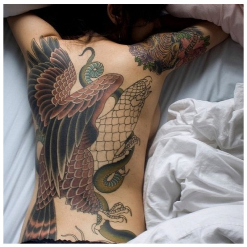 Fată cu tatuaj oriental pe spate.