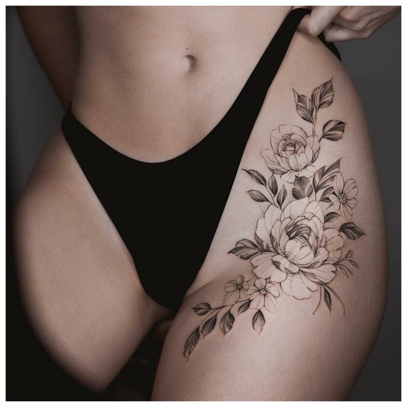Grand tatouage floral à la hanche