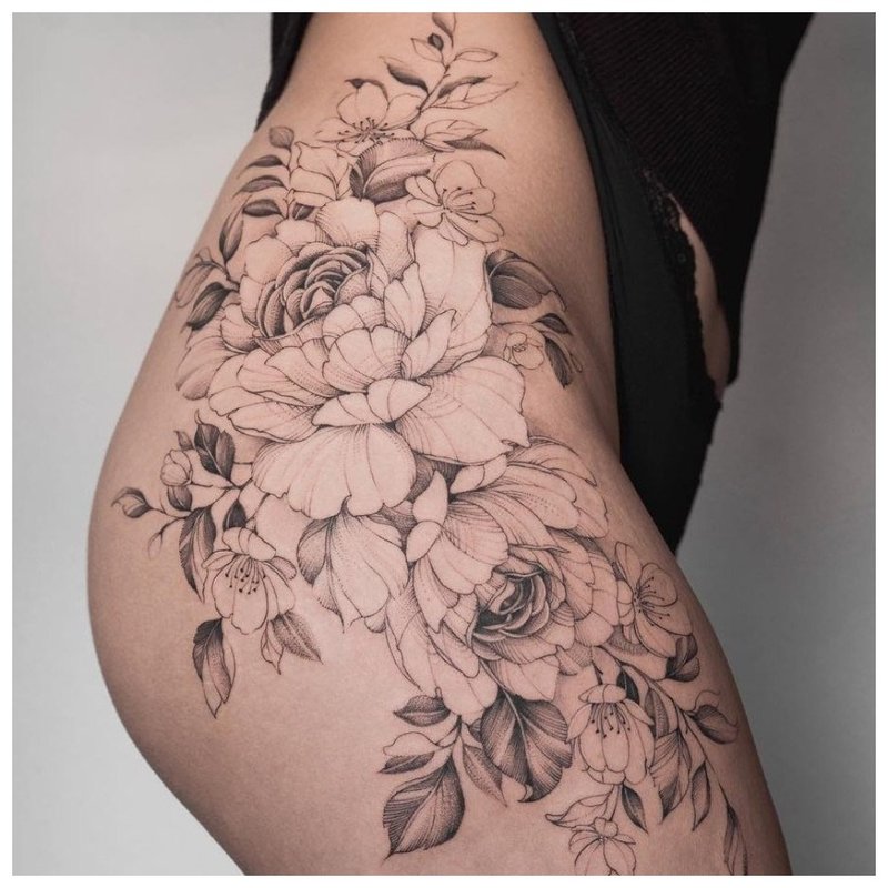 Attraktiv tatovering på hoften til en jente