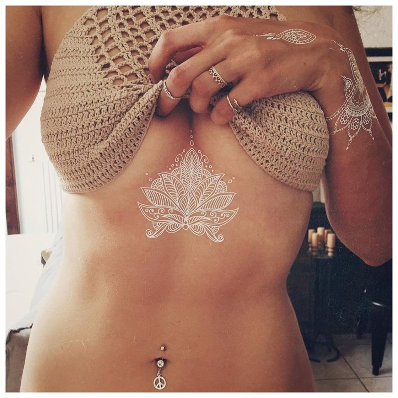 Hvit mehendi-tatovering under brystet