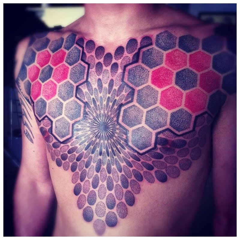 Lys tatovering på brystet til en mann i stil med en gjør-det-selv